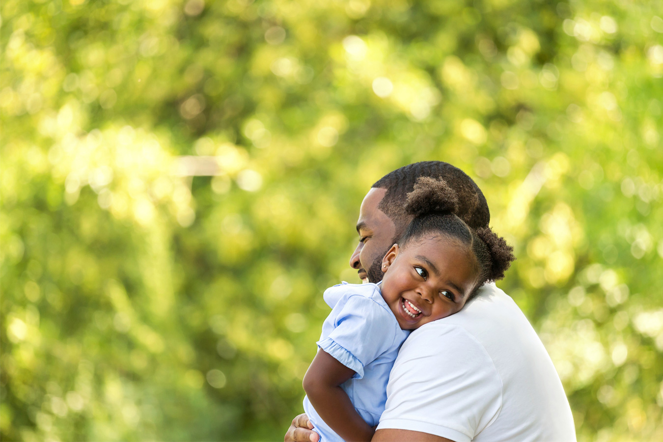 Father holding baby daughter outside